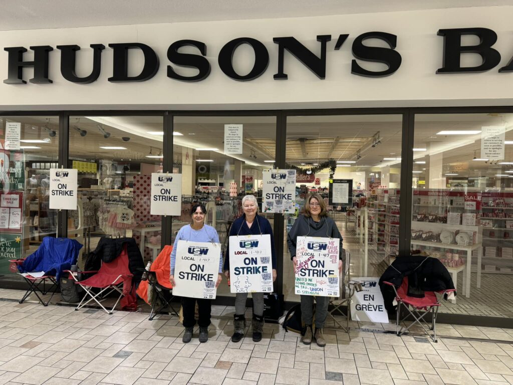 Three women holding USW 1-417 strike signs outside Hudson's Bay in Kamloops
