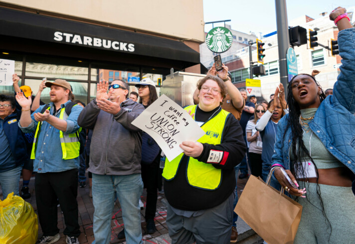 A group of people outside during a rally at a Starbucks coffee shop.