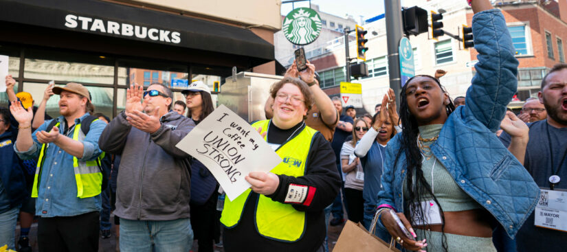 A group of people outside during a rally at a Starbucks coffee shop.