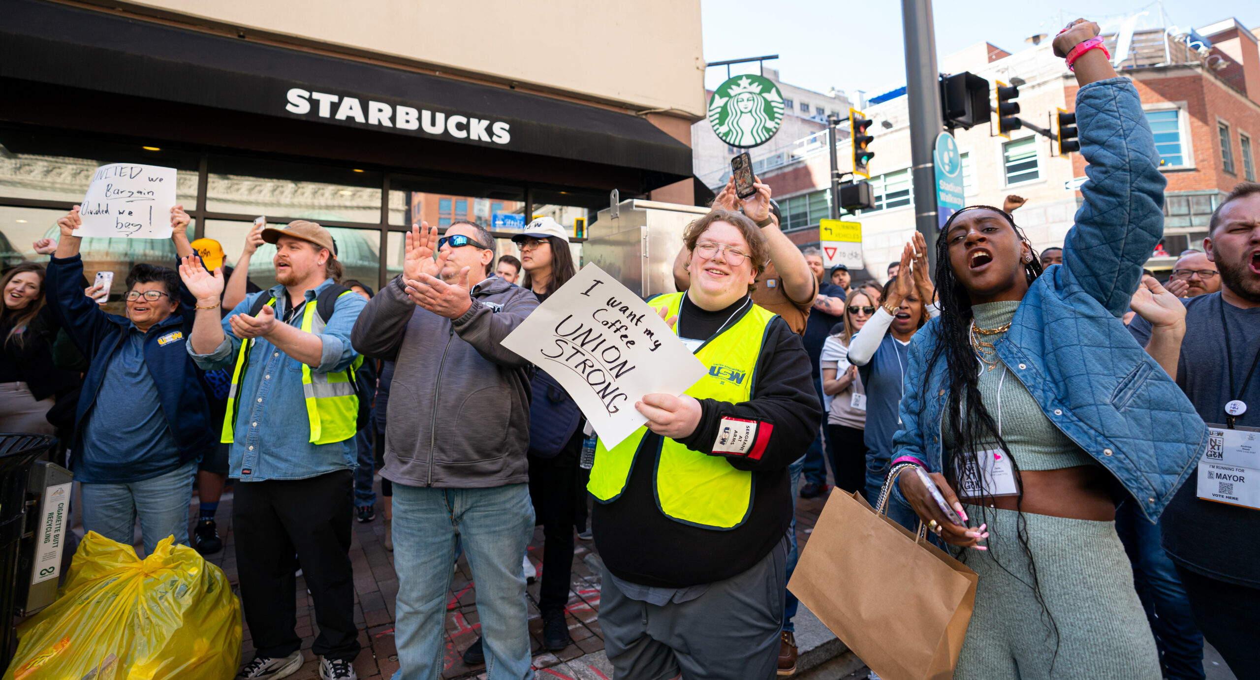 A group of people outside during a rally at a Starbucks coffee shop.