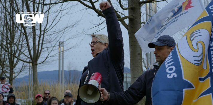 A person pumping its fist during a picket line. People holding signs appear in the background of the photo. There text saying: 2024 Labour Day Statement.