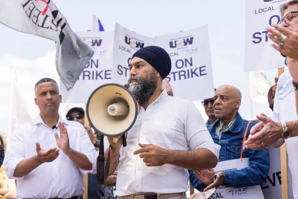 MP Mattew Green and NDP Leader Jagmeet Singh holding a megaphone , standing among USW workers on strike.