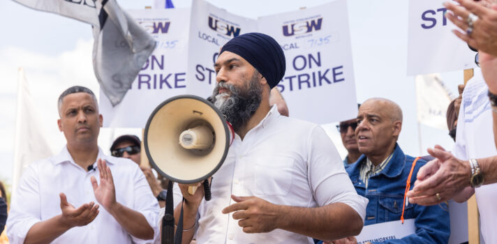 MP Mattew Green and NDP Leader Jagmeet Singh holding a megaphone , standing among USW workers on strike.