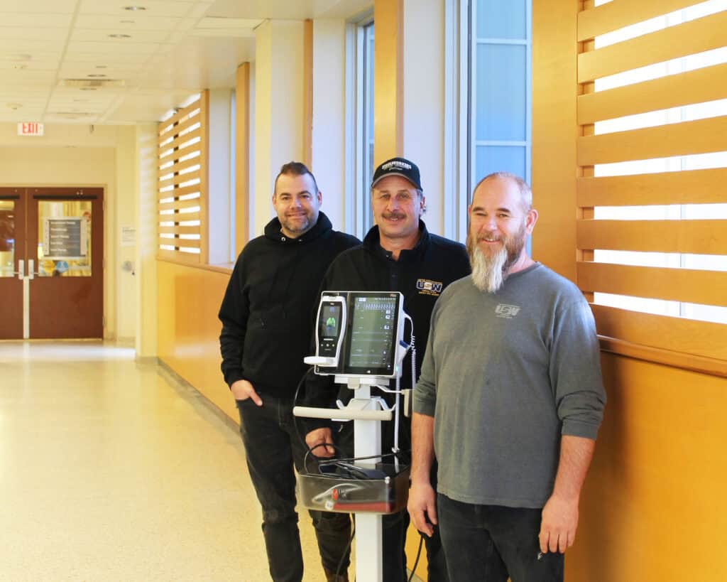 Three man standing in the hallway.