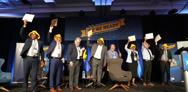 8 people standing on the stage and holding certificates