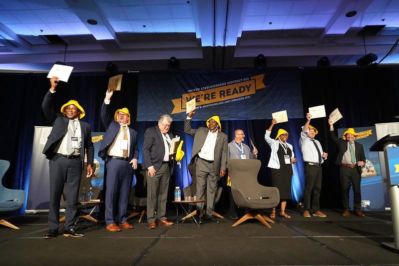 8 people standing on the stage and holding certificates