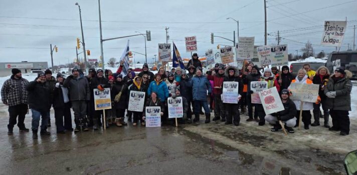 A large group of people standing with signs.