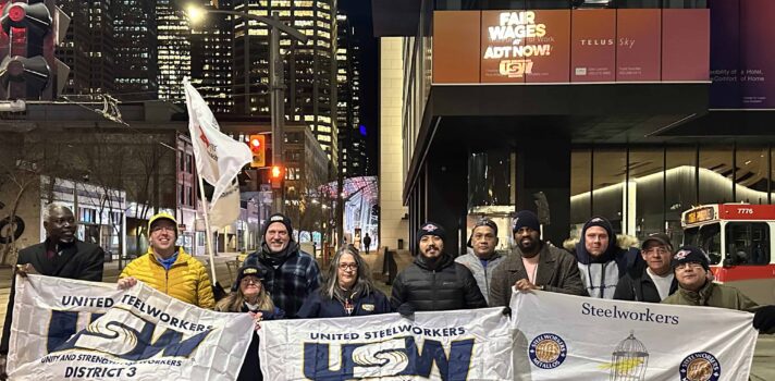 ADT by Telus Bat Light with members holding USW flags
